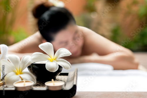 Close up Spa items. Background asian woman lying down on massage bed with scrub sugar and salt aroma at outdoor natural. wellness center, so relax and lifestyle. Thai Day Spa. Healthy Concept