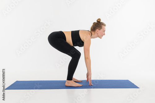 Sporty attractive young woman doing yoga practice on white background.