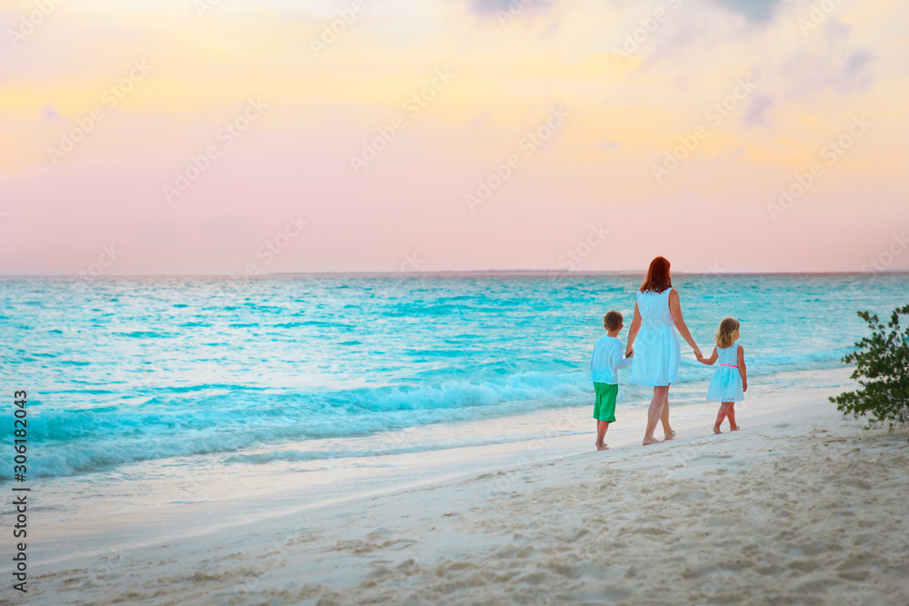 mother with little son and daughter walk on sunset beach mother with little son and daughter walk on sunset beach