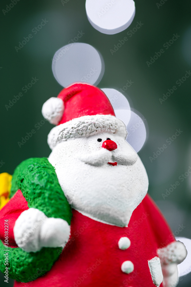 Close-up photo of gypsum colorful santa claus isolated over green background. New Year and Christmas concept.