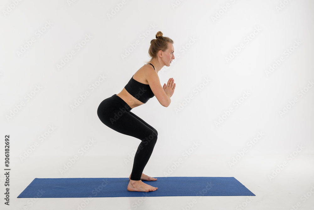 Sporty attractive young woman doing yoga practice on white background. Kursiasana. Sporty attractive young woman doing yoga practice on white background. Kursiasana.