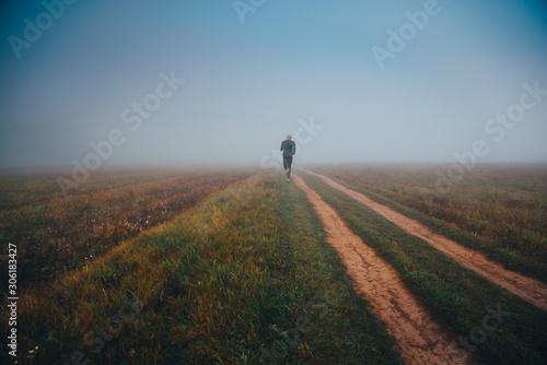 Runner in misty autumn morning nature