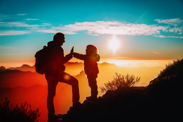 father and little daughter enjoy travel in mountains at sunset