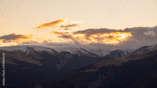 Mountain range with visible silhouettes through the morning colorful fog.Tarcu Mountains in Romania. photo