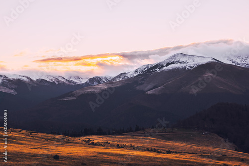 Fototapeta Naklejka Na Ścianę i Meble -  Mountain range with visible silhouettes through the morning colorful fog.Tarcu Mountains in Romania.