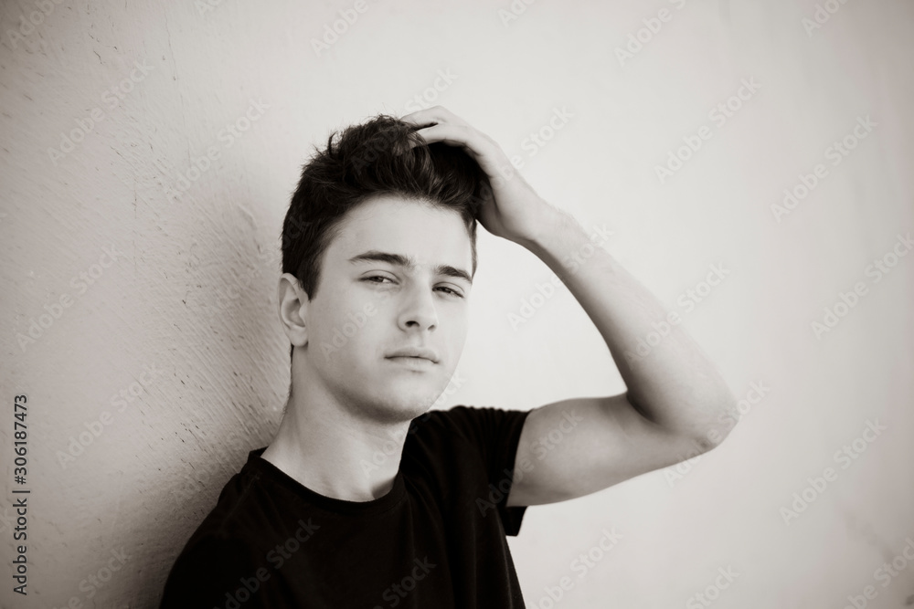 Young attractive man posing in front of camera in a black t-shirt Young attractive man posing in front of camera in a black t-shirt