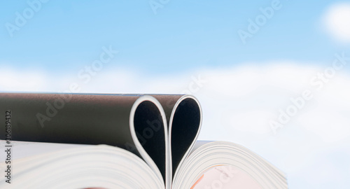  Open book with curled leaves in the shape of a heart.