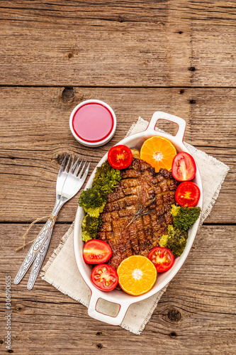 Fototapeta Naklejka Na Ścianę i Meble -  Baked duck breast on the bone with vegetables and sauce. Traditional healthy food concept. Vintage wooden boards background