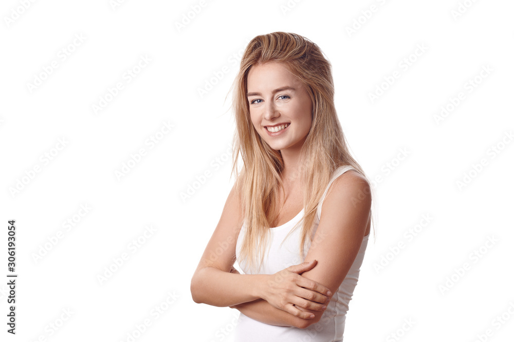 Beautiful blond young woman standing in white shirt with arms folded against white background, smiling and looking at camera. Half-turn half-length portrait Beautiful blond young woman standing in white shirt with arms folded against white background, smiling and looking at camera. Half-turn half-length portrait