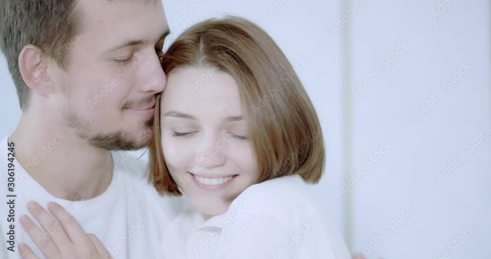 Girlfriend and boyfriend are snuggling and smiling in white room, 4k Girlfriend and boyfriend are snuggling and smiling in white room, 4k