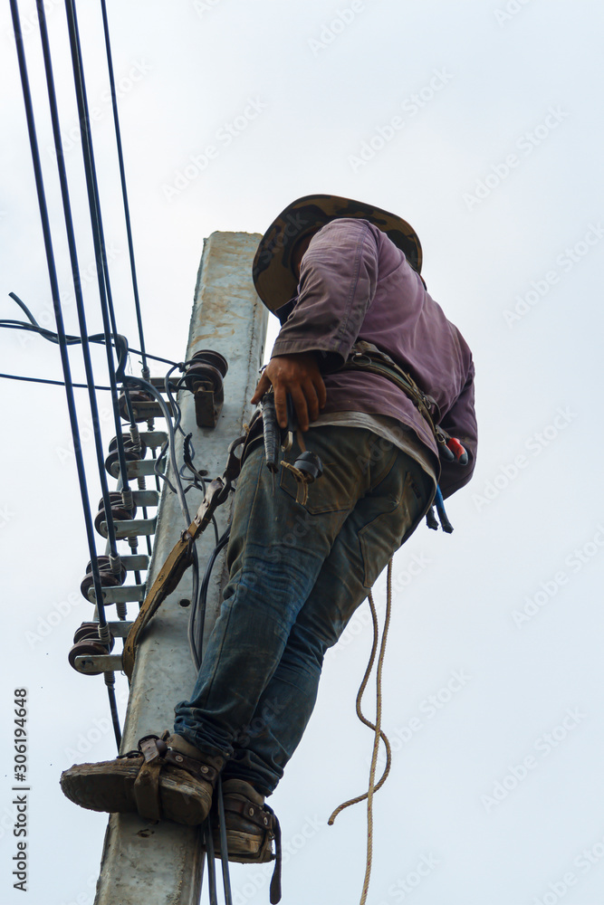  technician is fixing the system on the electric pole.