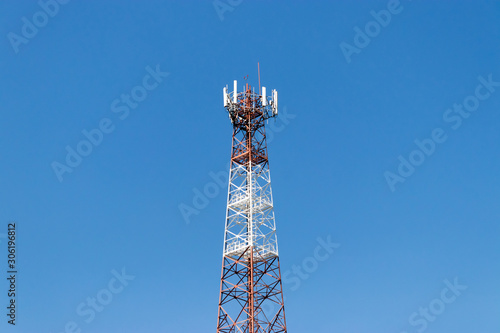 Mobile and telecommunication towers with a backdrop of bright blue skies.