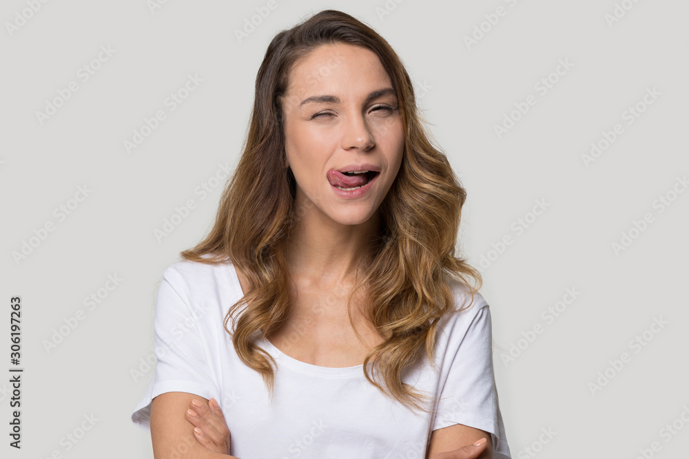 Attractive funny young woman showing tongue and winking Attractive funny young woman showing tongue and winking