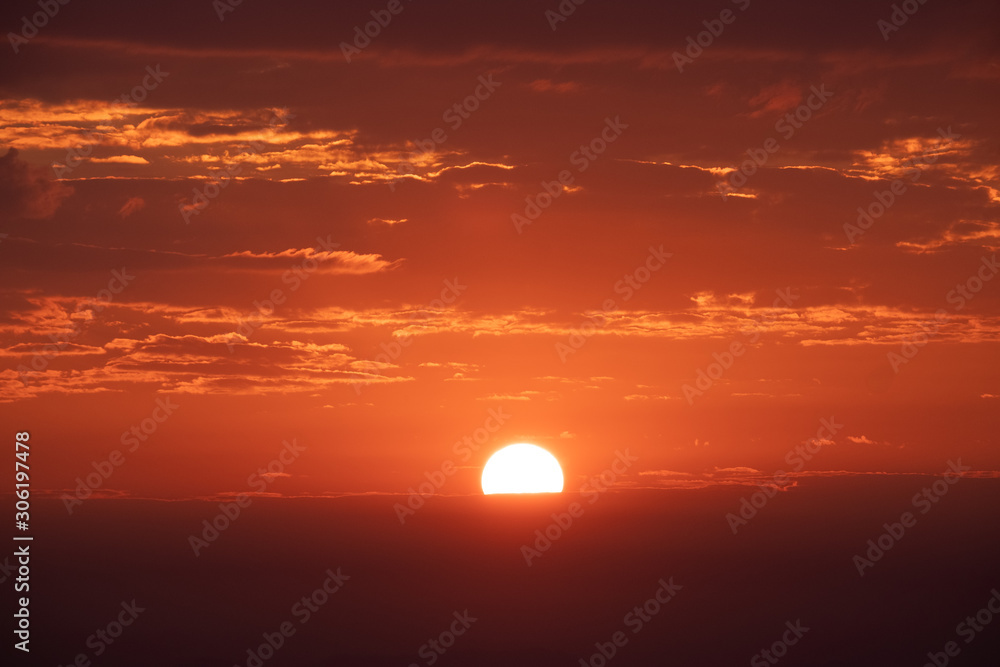 Bright orange sun and red sky during sunrise