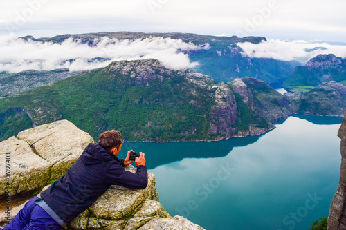 The man lying on Prekestolen photographs Lucefjord. Pulpit Rock. Norway.