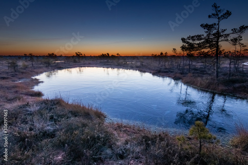 A frozen lake in Sooma National Park in Estonia during a freezing sunrise. 