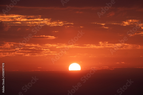 Bright orange sun and red sky during sunrise