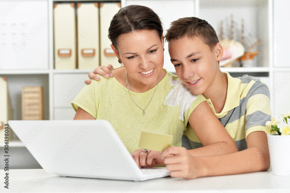 Portrait of mother and son using modern laptop shopping online Portrait of mother and son using modern laptop shopping online