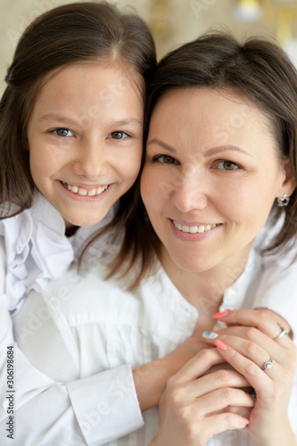Close up portrait of beautiful young mother and cute little daughter posing