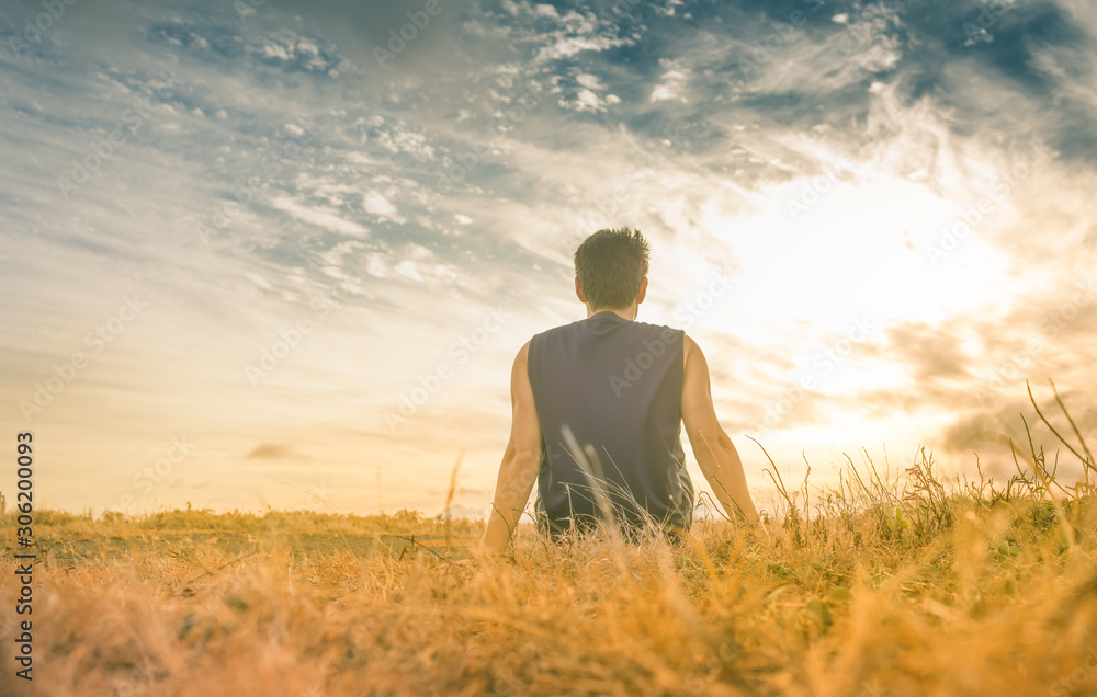 Ma sitting in a field watching the sunset. 