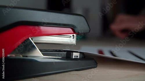 Stapling paper, closeup of man hands in office