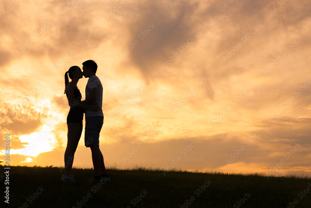 Young couple kissing at sunset. 