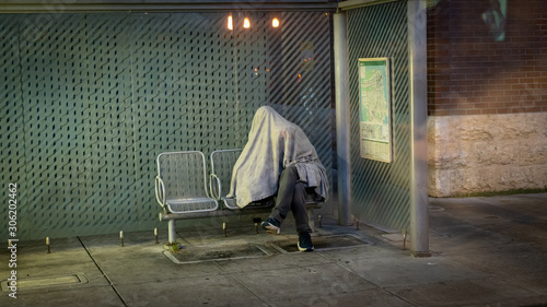 Canvas Print Homeless man sleeping in a bus stop