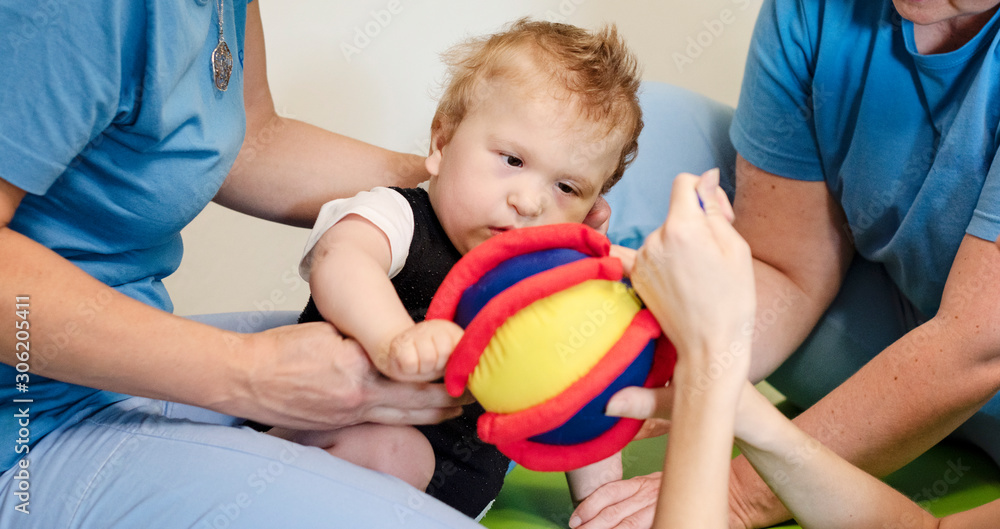 Portrait of a baby with cerebral palsy on physiotherapy in a children