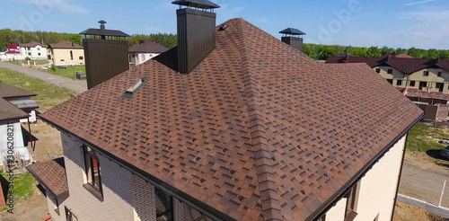 Bituminous tile for a roof. House with a roof from a bituminous tile. a roof from a bituminous tile. Moder