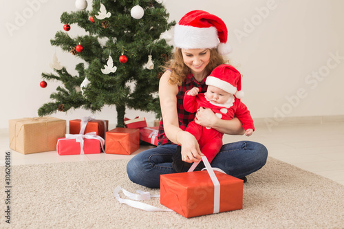 Family, childhood and Christmas concept - Portrait of happy mother and adorable baby in suit of Santa