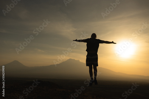 a man travels in Armenia  Yerevan. At sunset  she jumps silhouettes against the backdrop of Mount Ararat. Very beautiful landscape.