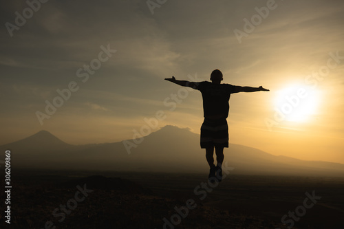 a man travels in Armenia, Yerevan. At sunset, she jumps silhouettes against the backdrop of Mount Ararat. Very beautiful landscape.