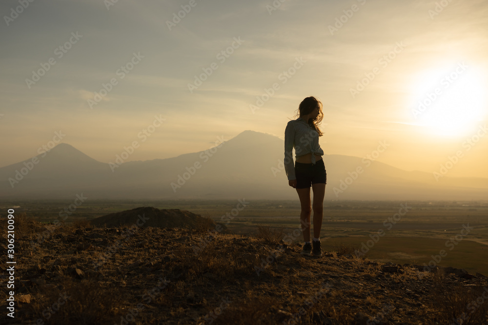 Beautiful and slender Girl travels in Armenia, Yerevan. At sunset, she jump silhouettes against the backdrop of Mount Ararat. Very beautiful landscape Beautiful and slender Girl travels in Armenia, Yerevan. At sunset, she jump silhouettes against the backdrop of Mount Ararat. Very beautiful landscape