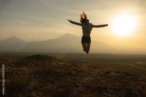 Beautiful and slender Girl travels in Armenia, Yerevan. At sunset, she jump silhouettes against the backdrop of Mount Ararat. Very beautiful landscape