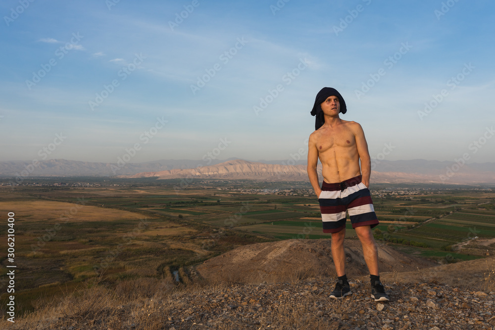 Fototapeta premium a man travels in Armenia, Yerevan. At sunset, she jumps silhouettes against the backdrop of Mount Ararat. Very beautiful landscape.