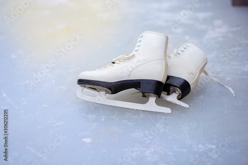 A pair of curly female skates lies on the ice at the rink
