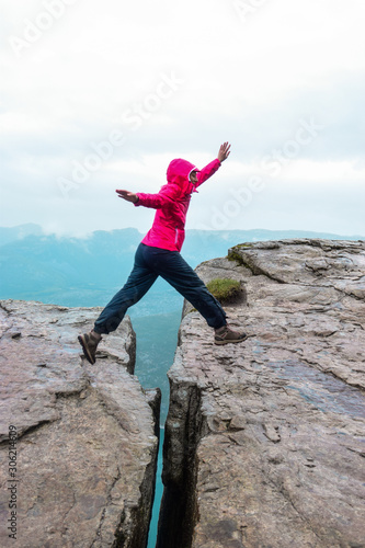 Girl on Prekestolen or Pulpit Rock in the rain. Norway. photo