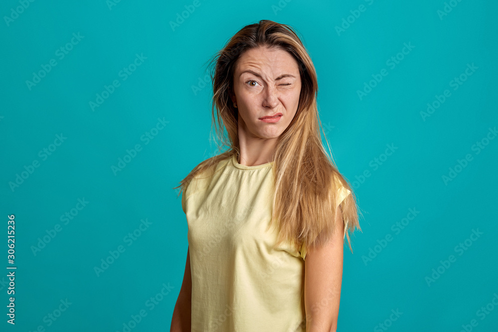 Studio portrait of a young fair-haired beautiful girl. Emotions of a girl on a blue background. Map of emotions. Studio portrait of a young fair-haired beautiful girl. Emotions of a girl on a blue background. Map of emotions.