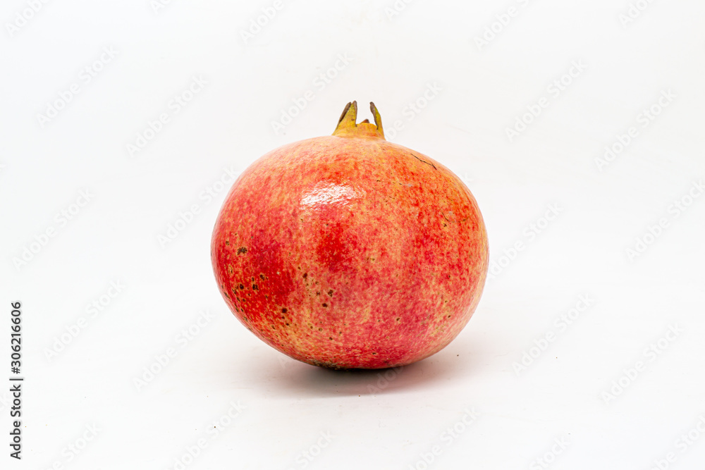 A whole pomegranate against a white background A whole pomegranate against a white background