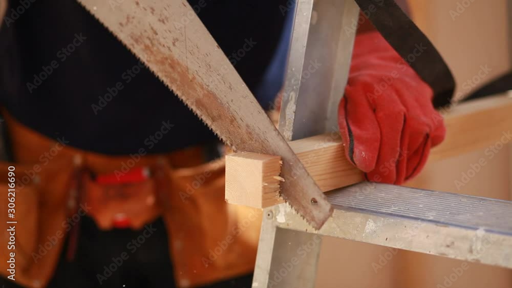 hands of young man working cutting plank with wood handsaw hands of young man working cutting plank with wood handsaw