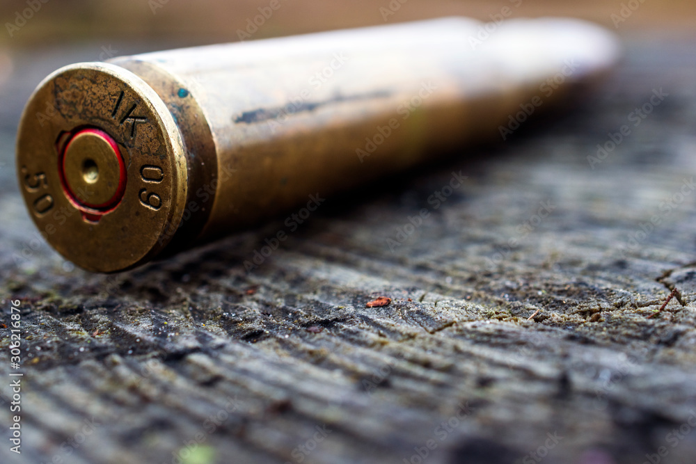 close up of 50 mm bullet on wooden background