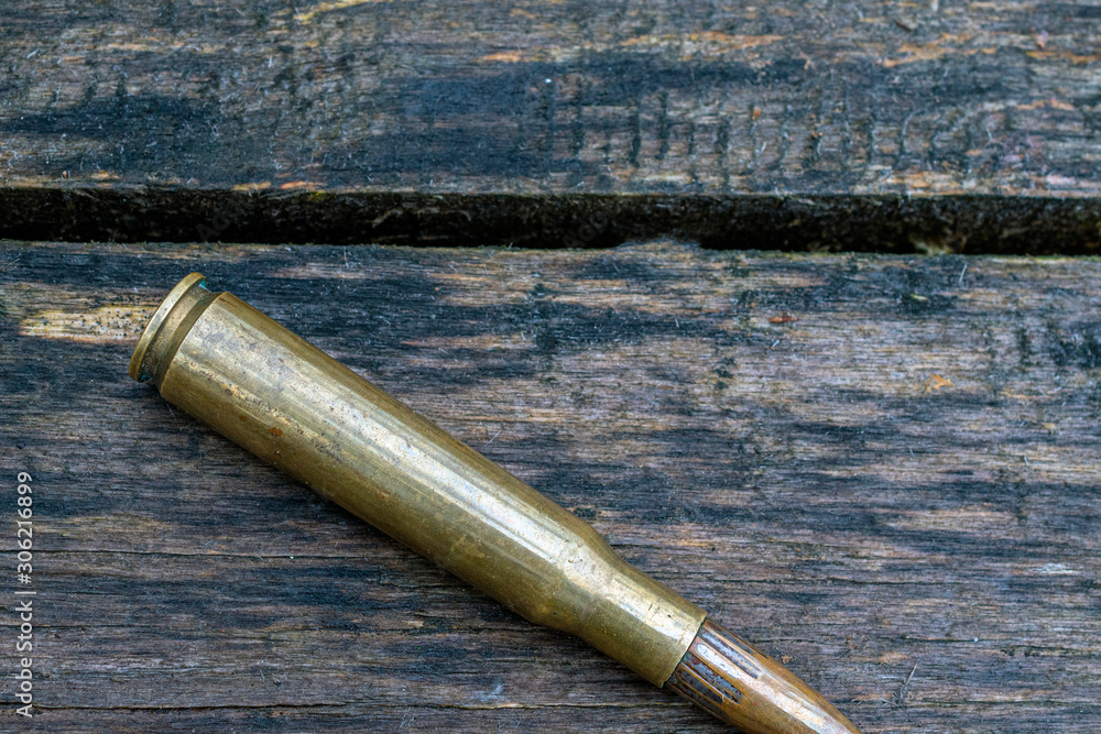 top view of big bullet on wooden background