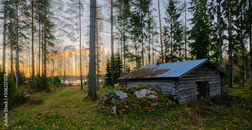 Obraz na płótnie wooden shed in the middle of forest, incredible sunset w salonie