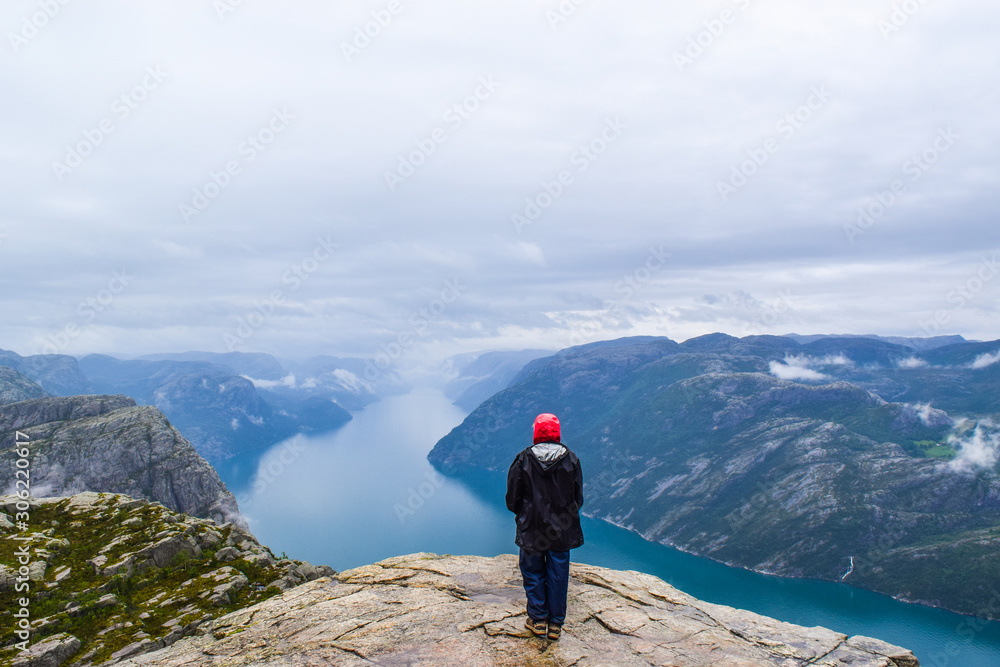 Girl on Prekestolen or Pulpit Rock in the rain. Norway.