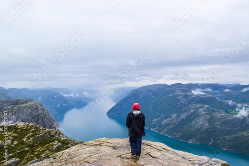 Girl on Prekestolen or Pulpit Rock in the rain. Norway.