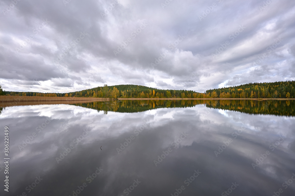 Incredible mirror-lake full of clouds, and forest in the background