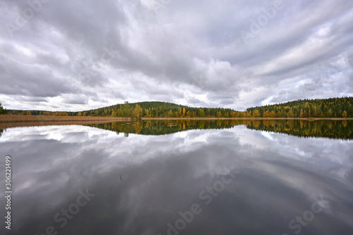 Obraz na płótnie Incredible mirror-lake full of clouds, and forest in the background w salonie
