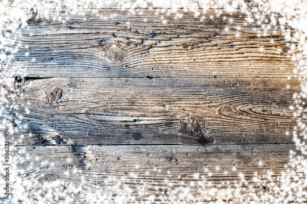 Naklejka premium Christmas wooden background with snow. View with copy space.