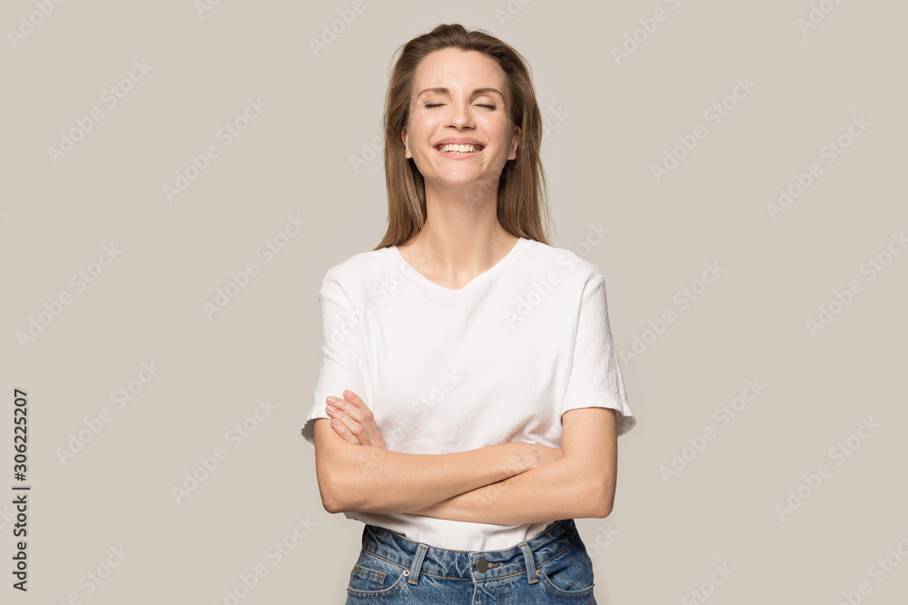 Happy smiling woman with arms crossed laughing at joke Happy smiling woman with arms crossed laughing at joke