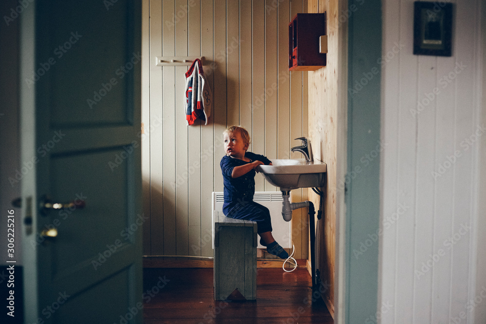 © Road Red Runner - Child washing in a country house sink, tender image of children developing their independence.